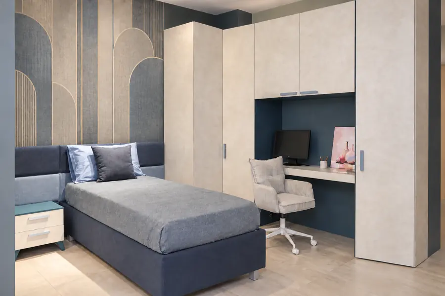 Cameretta su misura con letto singolo contenitore, armadio angolare, scrivania con passacavi, boiserie a quadrotti e comodino a due cassetti. Livein Camerette Mugnano.
